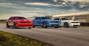 Three 2019 Dodge Challenger Hellcats in red white and blue driving on a performance track