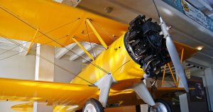 A yellow bi-plane on display at the Kansas Aviation Museum in Wichita, KS.
